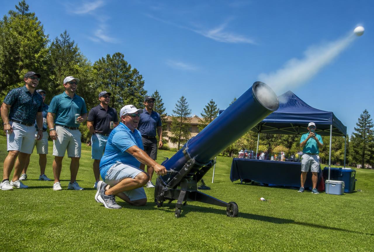 Volunteers firing the golf ball cannon at a charity golf outing